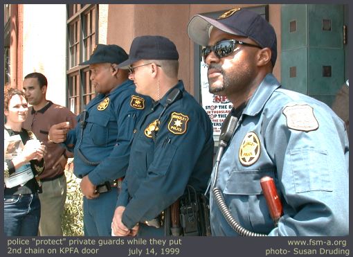 Police guarding placing of 2nd chain on KPFA door