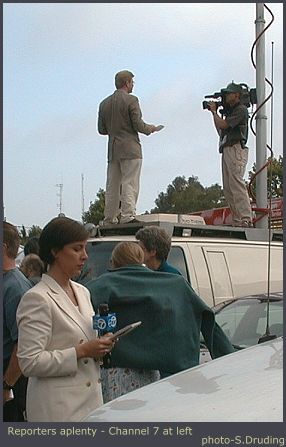 Channel 7 reporter and another in background on top of van