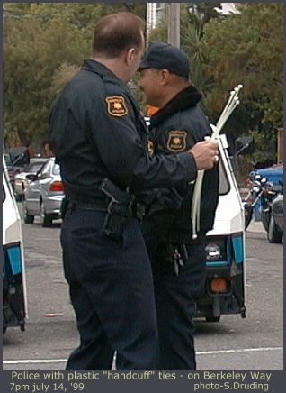 Police get plastic handcuffs out of van - 7pm